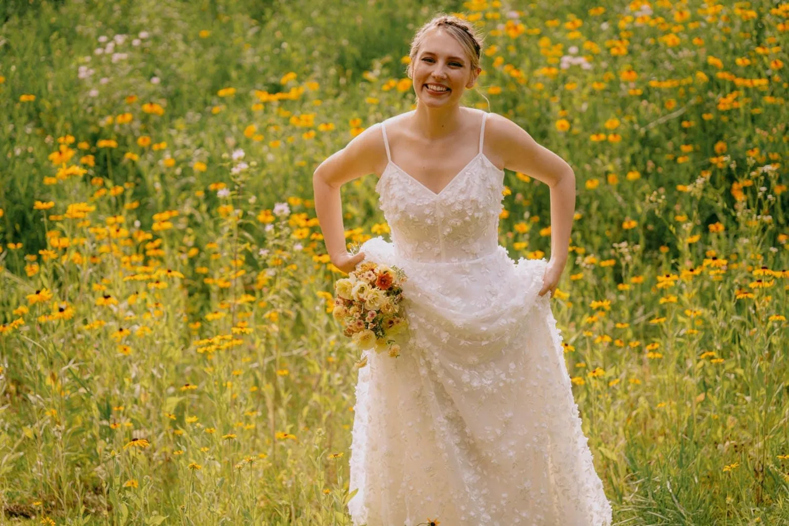 Hudson Valley bride smiling in a sunlit wildflower field at Troutbeck