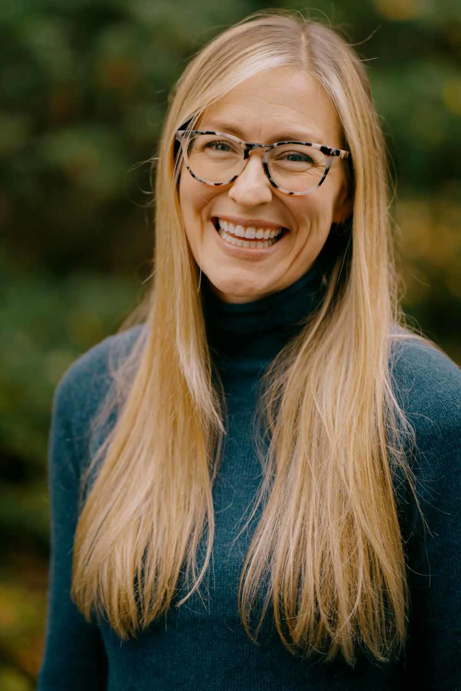 Hudson Valley professional headshot — outdoor natural-light portrait with a soft green leafy background
