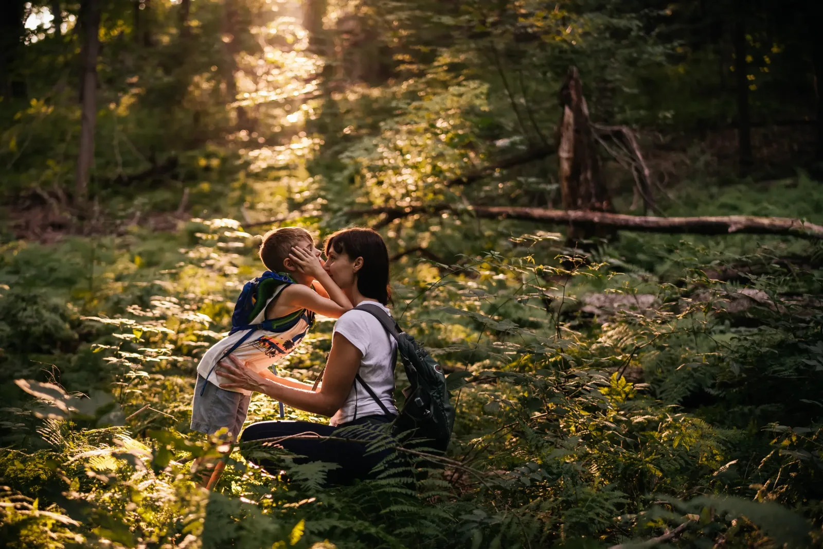 Hudson Valley family photography - son rests elbows on mom's shoulders during hike in Catskills