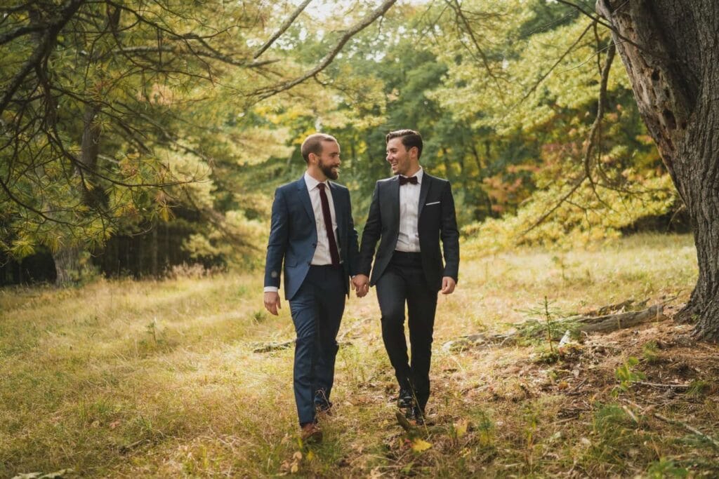 Gay couple hold hands and walk together in Catskills.