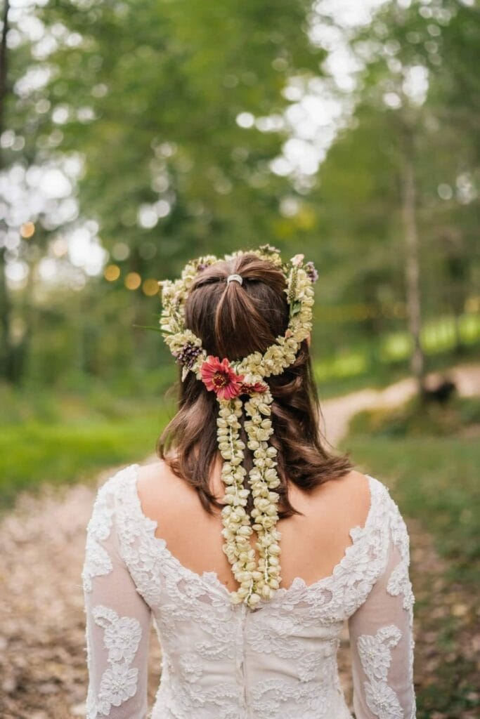 Bride's hair is decorated with flower wreaths and is wearing lace dress for wedding in Catskills.