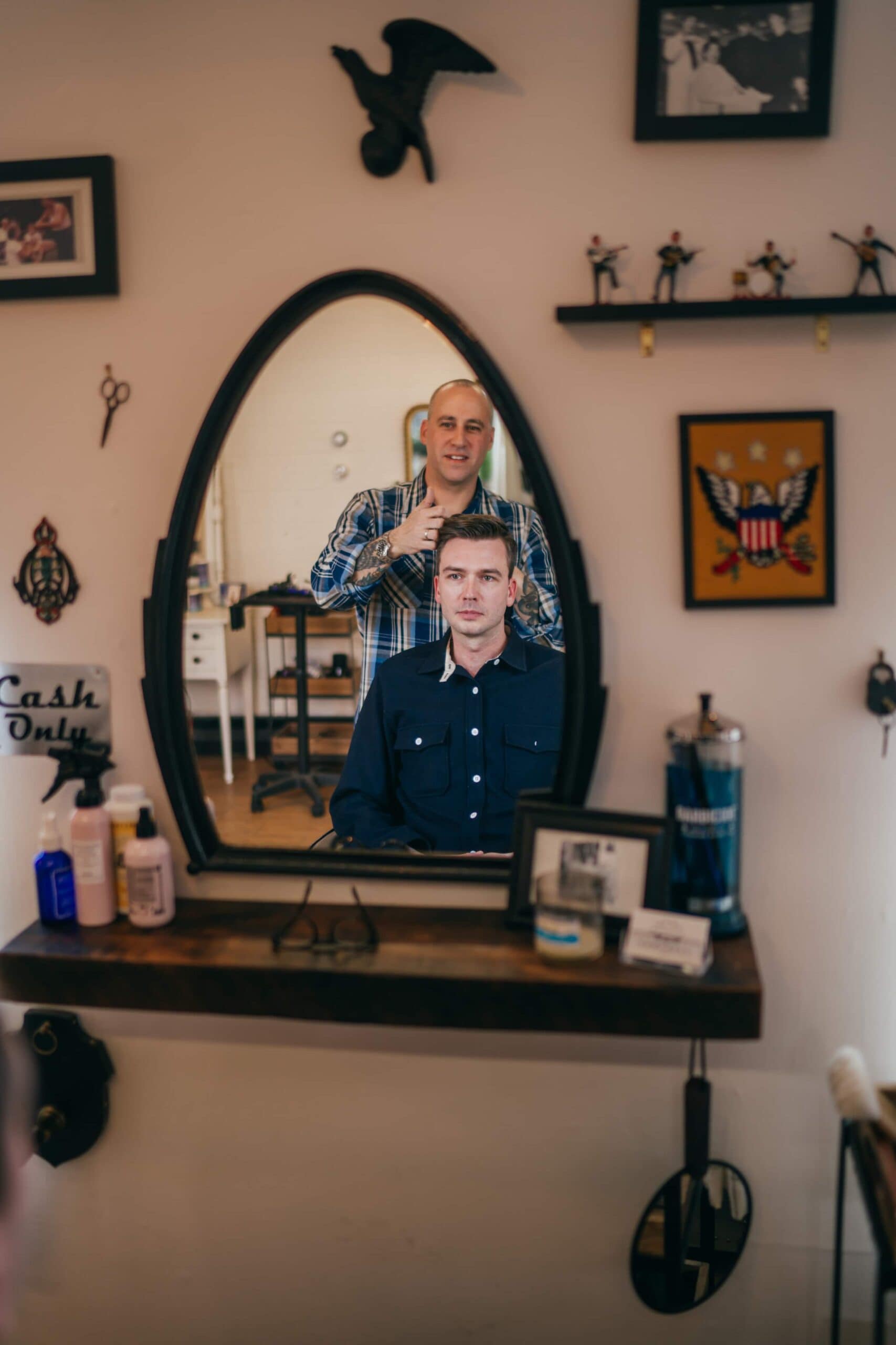 Bride sits as hairdresser does her hair for her wedding.