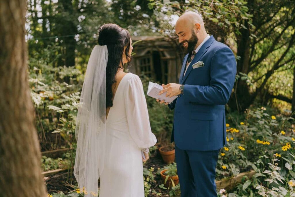 Bride and groom exchanging vows in forest setting.