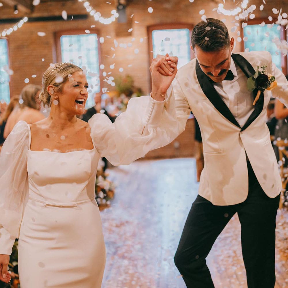 Joyful newlyweds dancing at wedding reception.